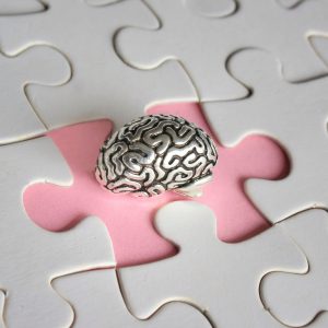 Alzheimer, amnesia, mental health concept. Brain model and missing puzzle pieces.