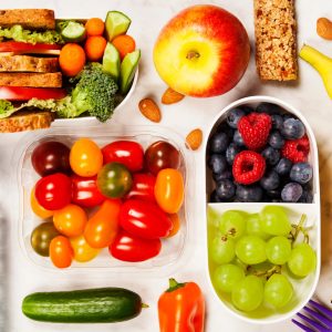 Healthy lunch box with sandwich and fresh vegetables, bottle of