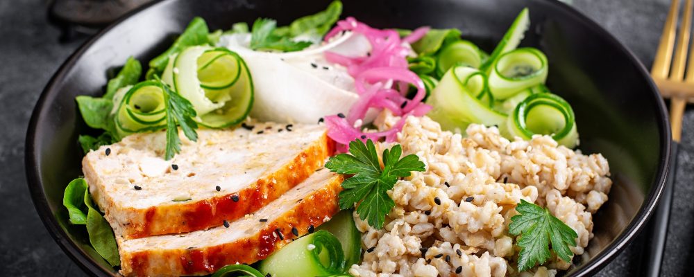 Plate with oatmeal, chicken meatloaf, cucumber and green herbs. Health food.