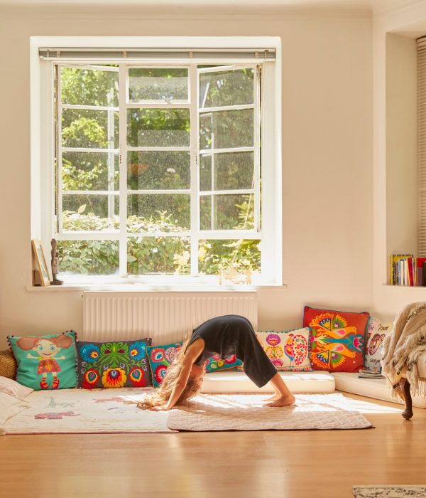 Young girl at home, bent over in yoga position